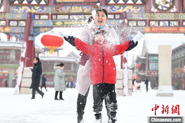 2月13日，家長與小朋友在呼和浩特市大召廣場(chǎng)享雪趣。　劉文華 攝