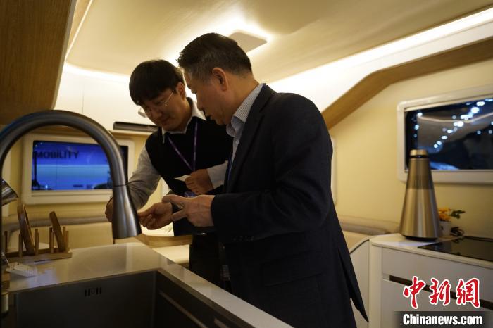 圖為參展商向觀眾介紹房車內(nèi)部設(shè)計?！⑿?攝