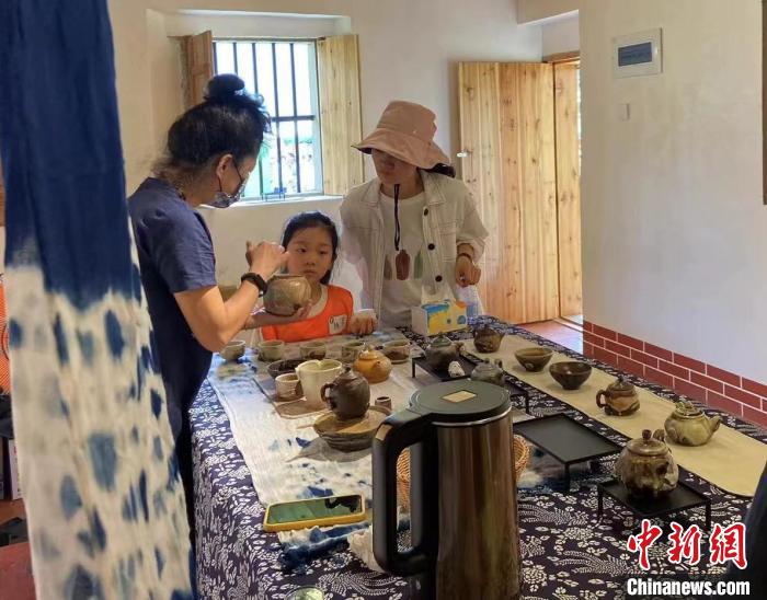 圖為：游客正在咨詢臺(tái)灣柴燒作品?！∪~秋云 攝