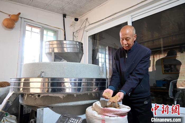 李家莊村民谷文朝重拾父輩的手藝，做起石磨面粉的營(yíng)生?！〉杂鸺?攝