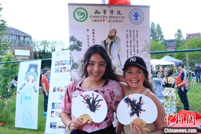 孩子們展示自己的吹墨畫團(tuán)扇作品?！◆斻肟鬃訉W(xué)院供圖