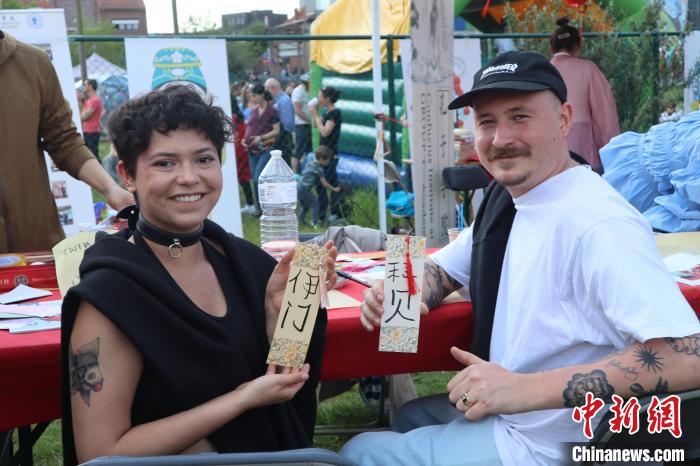 當(dāng)?shù)孛癖娫跐h字體驗(yàn)工作坊展示自己手寫的中文名書簽。　魯汶孔子學(xué)院供圖