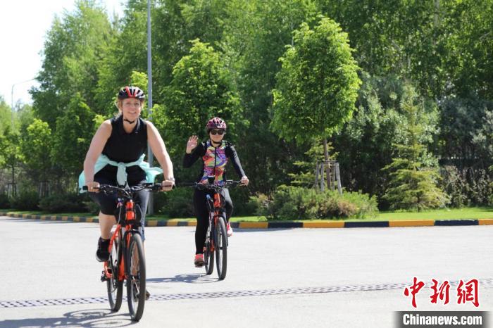 亞信副秘書長遲方(右一)與聯(lián)合國駐哈協(xié)調員在騎行活動中?！喰琶貢幑﹫D