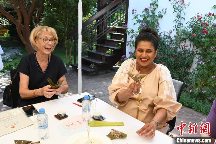 圖為嘉賓展示包粽子成果?！“亓种袊幕行墓﹫D。