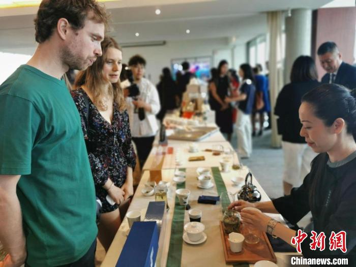 現(xiàn)場觀眾觀看中國展臺茶藝表演、了解茶文化。　靖樹 攝