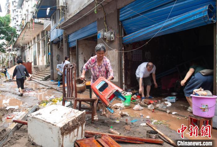 7月4日，萬州區(qū)五橋街道，洪水退去后，居民搶救生活物資?！∪矫宪?攝