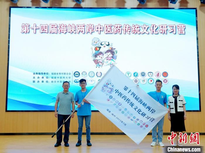 共青團(tuán)福建省委副書(shū)記吳雪(右一)、福建中醫(yī)藥大學(xué)黨委副書(shū)記林羽(左一)為兩岸學(xué)生代表頒授營(yíng)旗?！≡S燁婷 攝