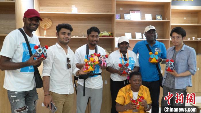 圖為國際青年代表展示親手制作的東營非遺黃河口布偶 ?！↓R魯 攝