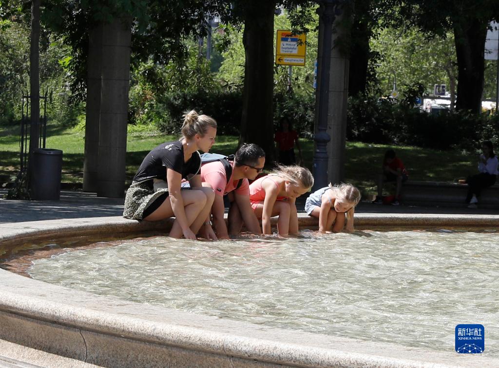 7月8日，人們在德國法蘭克福的一處噴泉玩水。近日，德國法蘭克福逐漸迎來暑熱天氣。新華社記者 張帆 攝