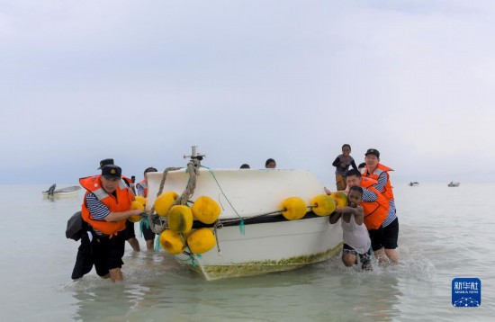 7月21日，中國海軍“和平方舟”號(hào)醫(yī)院船醫(yī)護(hù)人員涉水登島，前往基里巴斯一診療點(diǎn)。新華社記者 黎云 攝