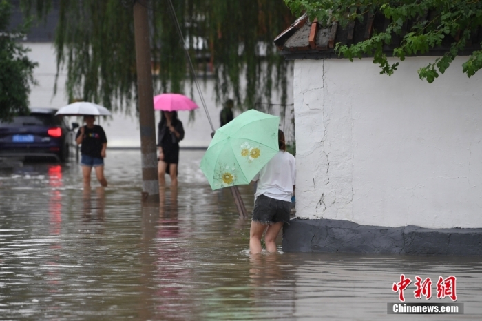 7月31日，市民行走在雨中的北京房山區(qū)瓦窯頭村。北京市氣象臺當(dāng)日10時發(fā)布分區(qū)域暴雨紅色預(yù)警信號。北京市水文總站發(fā)布洪水紅色預(yù)警，預(yù)計(jì)當(dāng)日12時至14時，房山區(qū)大石河流域?qū)⒊霈F(xiàn)紅色預(yù)警標(biāo)準(zhǔn)洪水。<a target='_blank' href='/'><p  align=