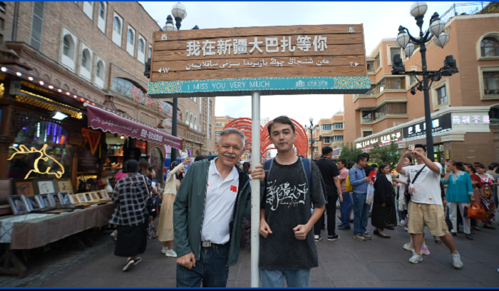潘維廉和維吾爾族青年伊木蘭“打卡”大巴扎。主辦方供圖
