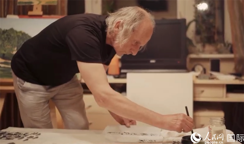 伊戈爾·布爾東諾夫在畫作上題詞。人民網(wǎng)記者 馬天翼攝