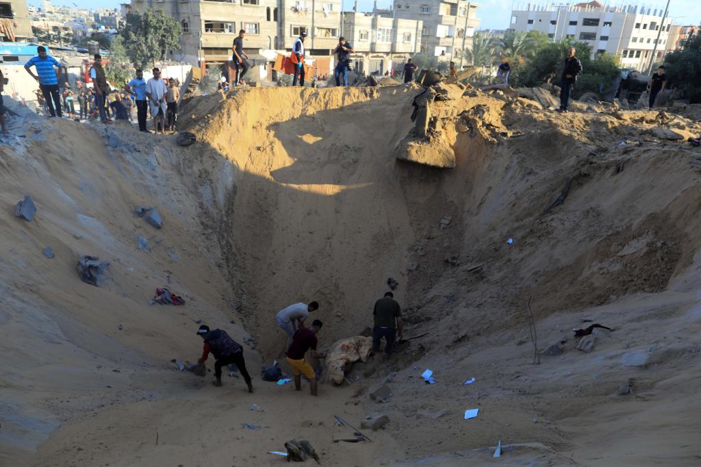 10月16日，在加沙地帶南部城市汗尤尼斯，人們?cè)谠庖陨幸u擊后的建筑廢墟中救援傷者。 新華社發(fā)（亞西爾·庫迪 攝）