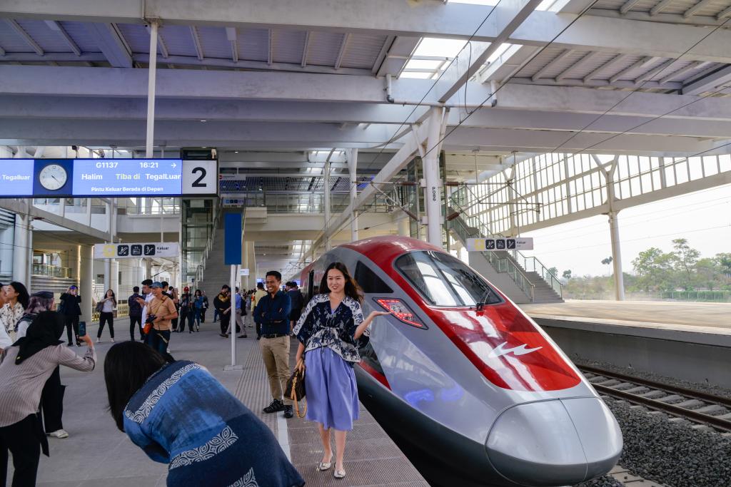 10月17日，在印度尼西亞萬隆德卡魯爾站，乘客在站臺上和雅萬高鐵高速動車組列車合影。