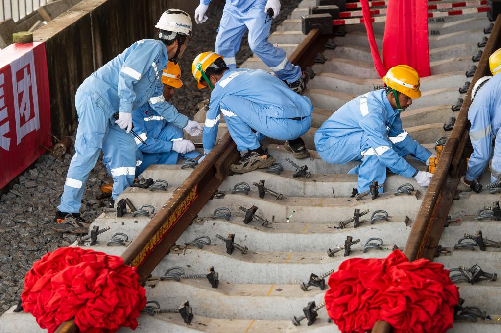 3月31日，在印度尼西亞雅加達雅萬高鐵哈利姆車站，工人鋪設(shè)雅萬高鐵全線最后一根鋼軌。