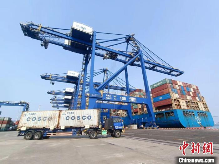 圖為海南洋浦國(guó)際集裝箱碼頭，卡車(chē)將集裝箱從后方堆場(chǎng)運(yùn)往碼頭裝卸區(qū)?！?jiān)潞?攝