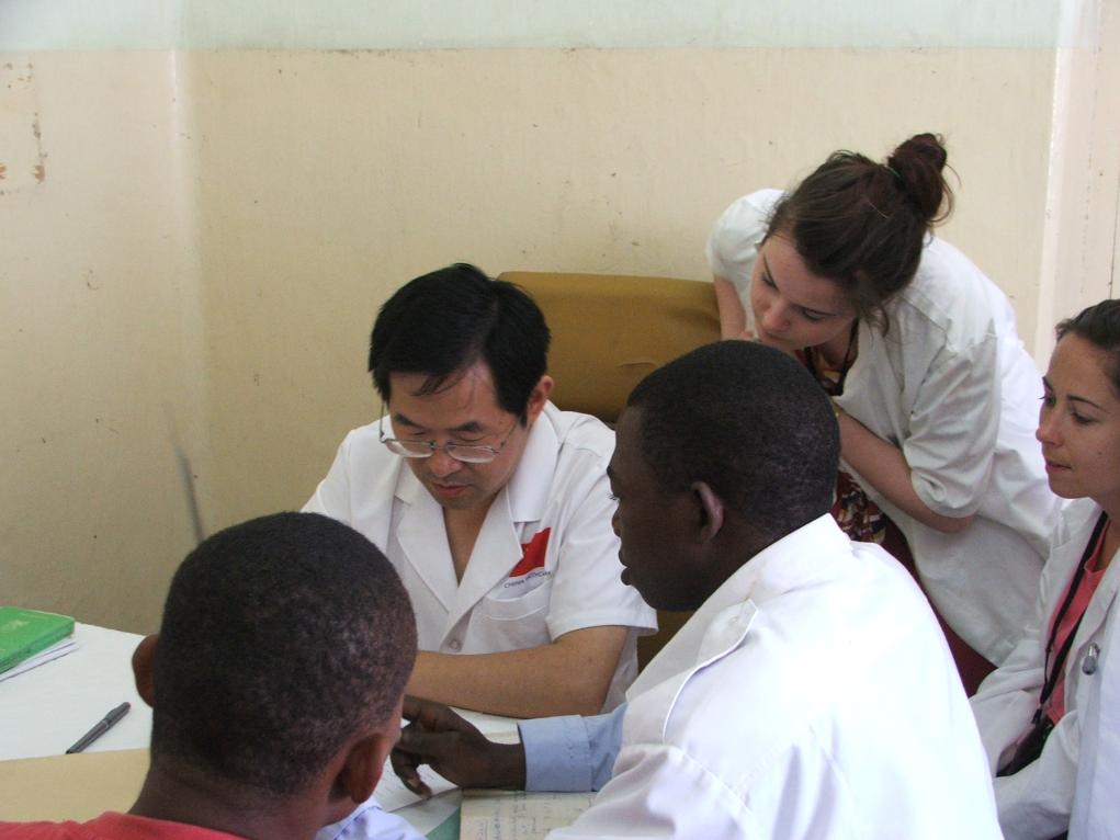 2011年7月22日，在坦桑尼亞桑給巴爾納茲莫加醫(yī)院外科門診，中國第24批援桑給巴爾醫(yī)療隊隊長盧建林為當?shù)鼗颊咴\治并帶教實習生。新華社發(fā)（國家衛(wèi)生健康委供圖）