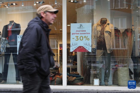   10月31日，一名男子從比利時布魯塞爾一家貼有打折信息的店鋪前走過。新華社記者 趙丁喆 攝