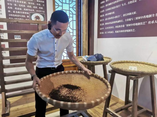 2023“一帶一路”媒體合作論壇聯(lián)合采訪團(tuán)團(tuán)員在非遺文化展示館體驗(yàn)中藥炮制技藝。（本報(bào)記者 黃超攝）