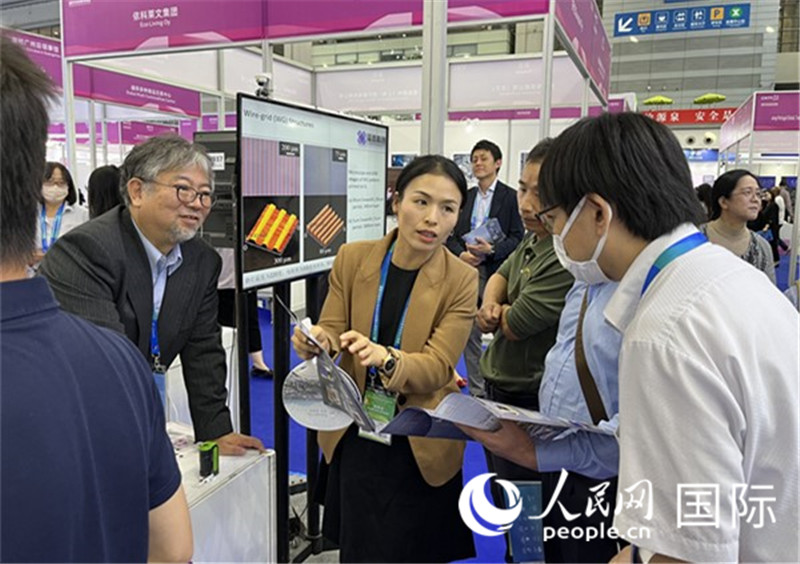 工作人員向參觀者介紹超級噴墨技術(shù)。（人民網(wǎng)記者 陳思攝）