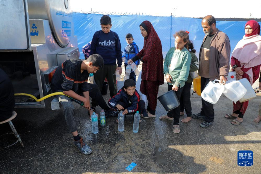 12月8日，在加沙地帶南部城市拉法一處臨時(shí)營(yíng)地內(nèi)，人們排隊(duì)打水。新華社發(fā)（里澤克·阿卜杜勒賈瓦德 攝）