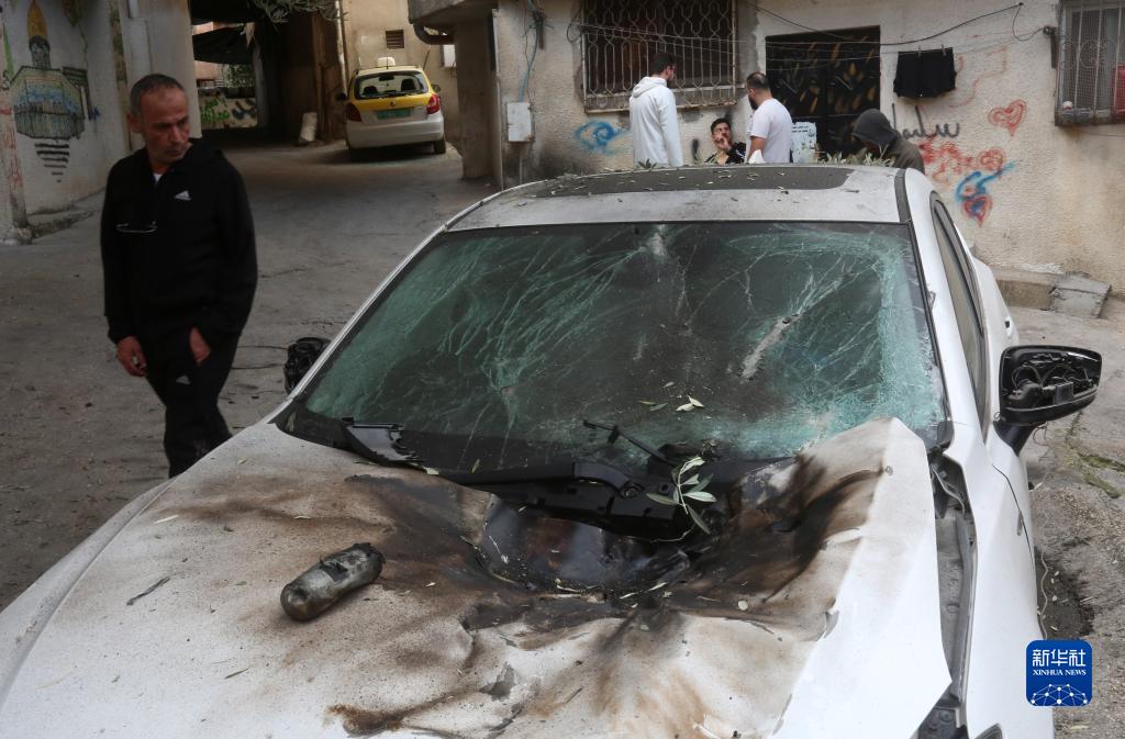 12月17日，在約旦河西岸城市圖勒凱爾姆附近的一處難民營(yíng)，人們查看在沖突中損毀的車輛。新華社發(fā)（尼達(dá)爾·艾仕塔耶?dāng)z）