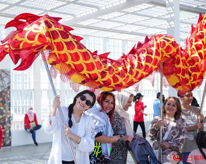 游客體驗(yàn)舞龍。 人民網(wǎng) 塔里克·易卜拉欣攝