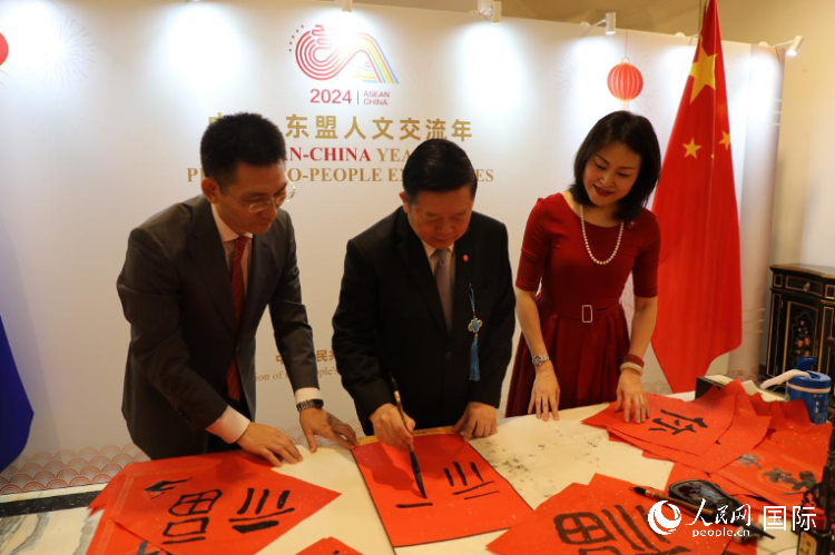 東盟秘書長高金洪（中）在活動現(xiàn)場寫福字。人民網(wǎng)記者曹師韻攝