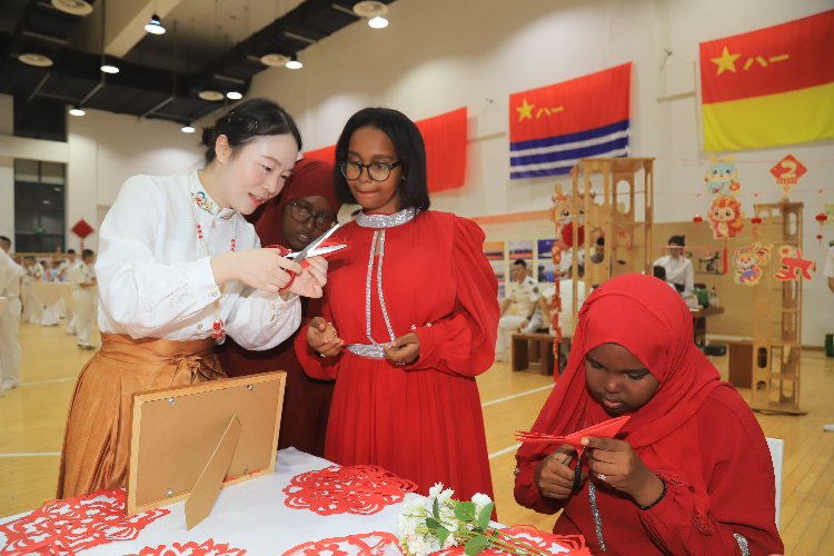 中國剪紙藝術吸引當?shù)厝耸繀⑴c體驗。陳錦俊攝