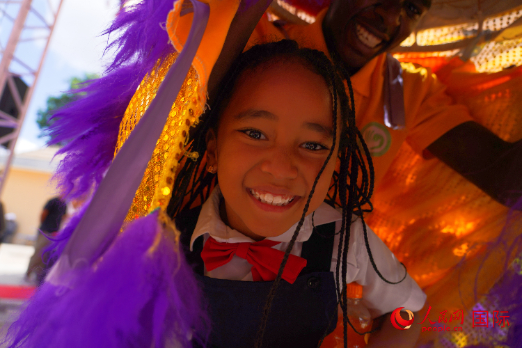 一名小朋友在與舞獅表演者互動。人民網(wǎng)記者 黃煒鑫攝