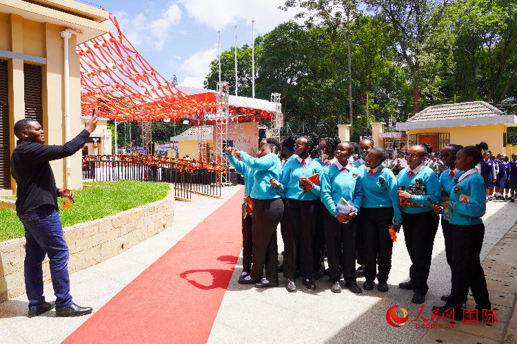 一名老師在給學(xué)生拍照留念。人民網(wǎng)記者 黃煒鑫攝