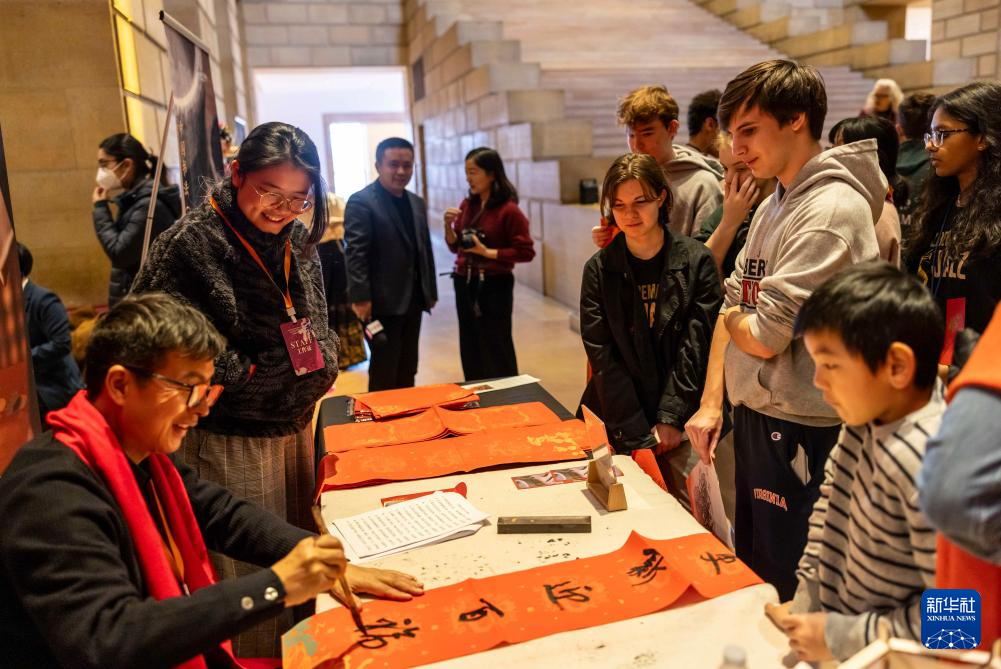 2月11日，書法家在美國費城藝術博物館舉行的龍年迎新春活動上為參觀者書寫對聯(lián)。新華社發(fā)（周煥新攝）