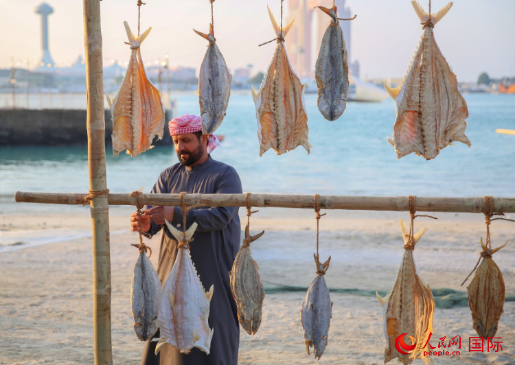    手工藝者展示如何晾曬魚干。人民網(wǎng) 塔里克·易卜拉欣攝