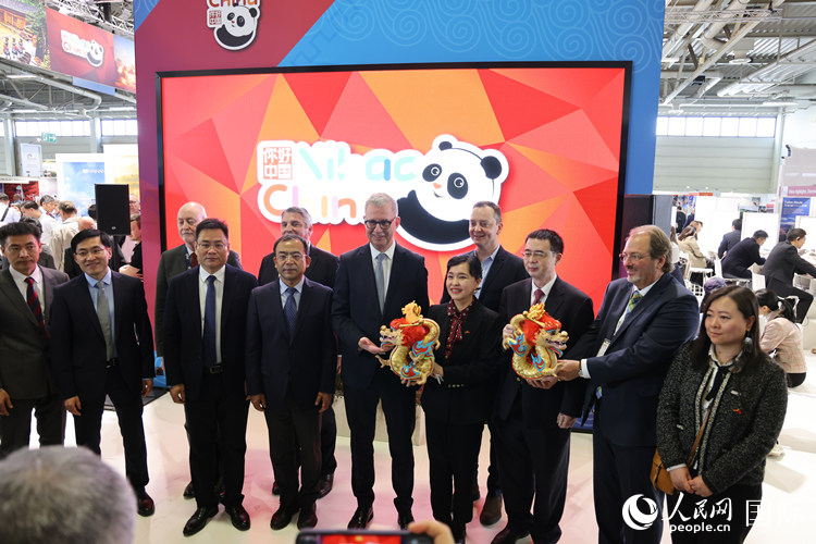 參加中國館開幕式的嘉賓們?cè)凇澳愫?中國” 展臺(tái)前合影留念。