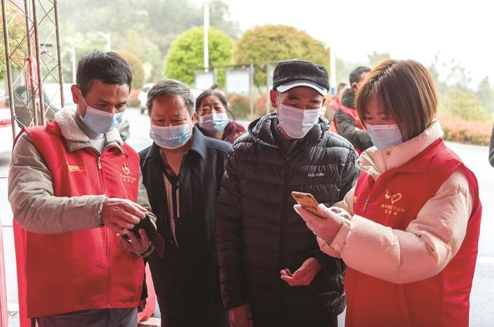長沙縣黨員志愿者正在幫助參與核酸檢測(cè)的群眾掃描“場所碼”。劉思源 攝