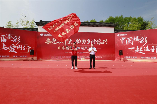 為媒體采風(fēng)團(tuán)授旗。 山東省福彩供圖