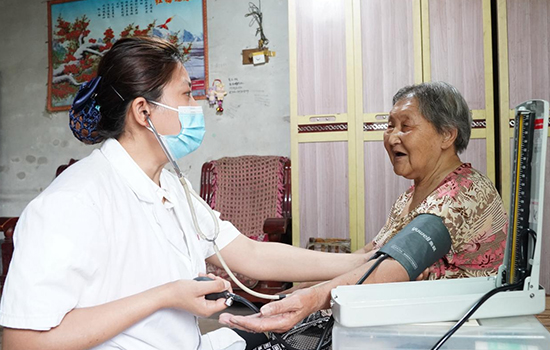 護(hù)理團(tuán)隊(duì)醫(yī)生為老人測(cè)量血壓。 陳佳兵攝