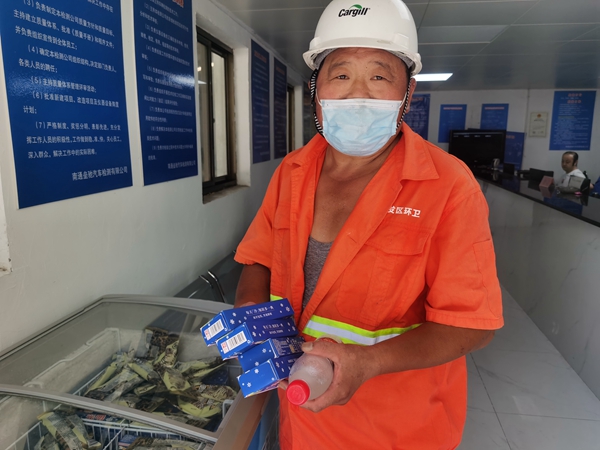 1環(huán)衛(wèi)工倪建宏小憩后，為還同事帶去冷飲。人民網(wǎng)記者王繼亮攝