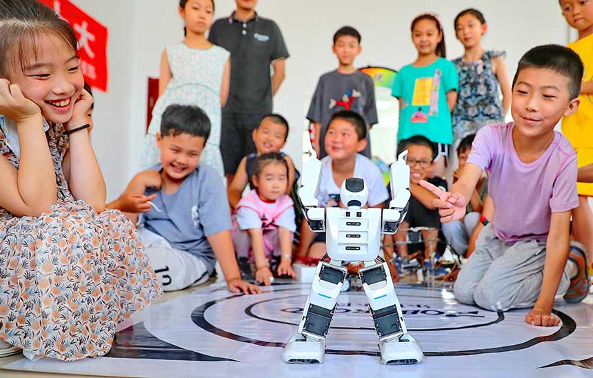 2022年7月19日，河北省秦皇島市海港區(qū)白塔嶺街道秦皇半島第二社區(qū)內，小朋友正在觀看“機器人跳舞”。 曹建雄攝