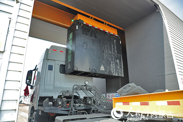 萬利新能源數(shù)字陸港里，正在充換電站進(jìn)行換電的重卡。人民網(wǎng)記者 趙夢月攝