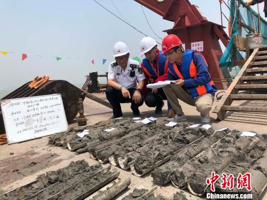 圖為勘察設計人員與海事局工作人員查看巖芯情況。　魏震 攝