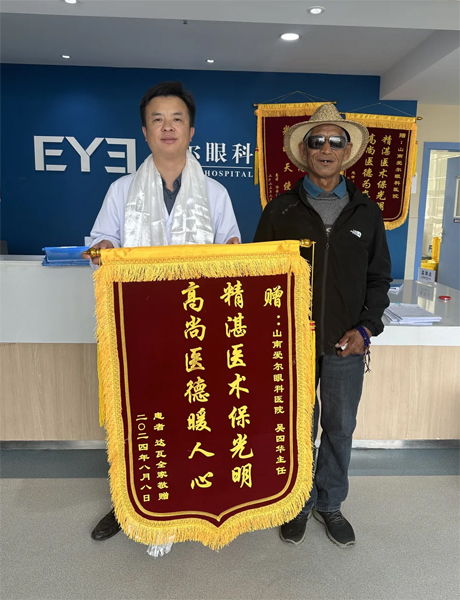 達(dá)瓦老人向吳四華（左）贈(zèng)送錦旗。受訪者供圖