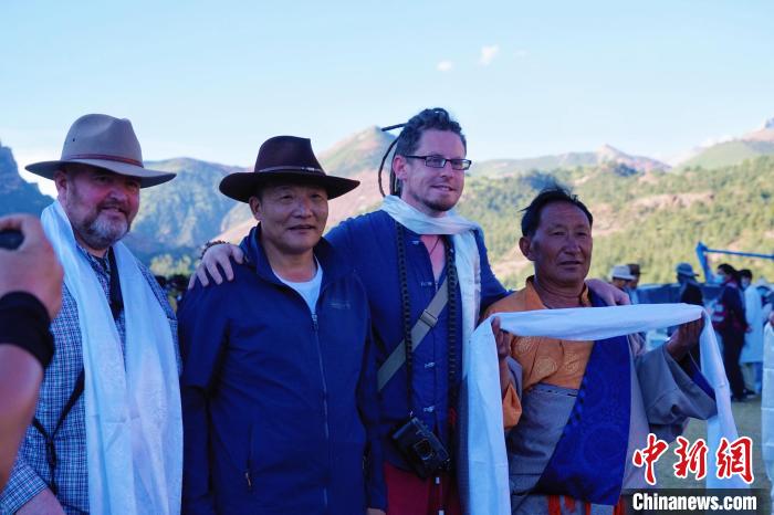 圖為當(dāng)?shù)孛癖娕c外籍?dāng)z影師合影留念?！●R銘言 攝