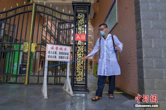 資料圖：?？诮?jīng)濟(jì)學(xué)院的工作人員在學(xué)生宿舍樓入口消毒。 中新社記者 駱云飛 攝