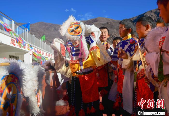 圖為加查縣安繞鎮(zhèn)小學(xué)學(xué)生在試穿藏戲面具?！∝暩聛硭?攝