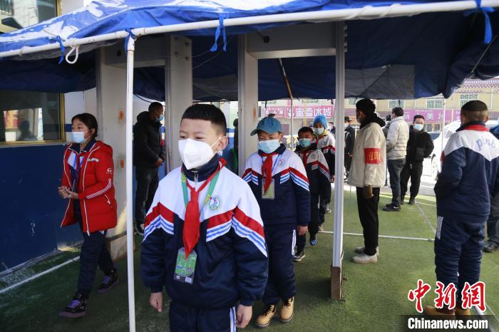 圖為學(xué)生測量體溫后進(jìn)入校園?！●R銘言 攝