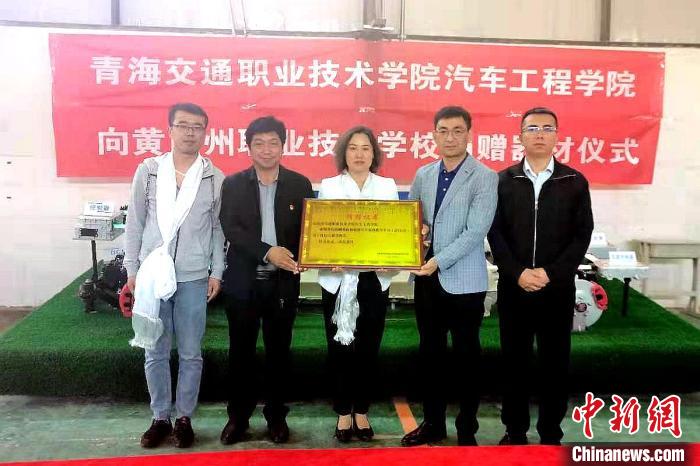 圖為李富香(中)代表學(xué)校為州縣技校捐贈(zèng)器材。(資料圖) 青海省教育廳供圖