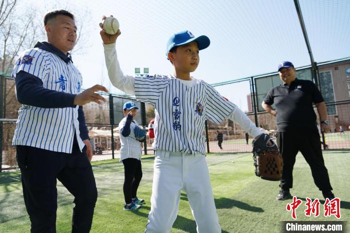 圖為教練指導(dǎo)小棒球手?jǐn)S球技術(shù)?！●R銘言 攝