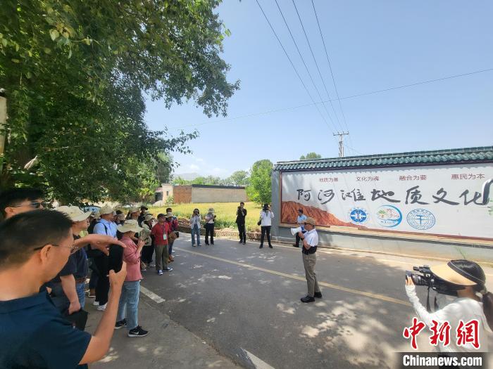 圖為中國地質(zhì)大學(xué)(北京)教授張緒教介紹村落情況?！『衍?攝